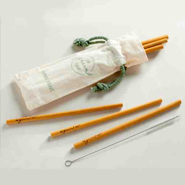 image of bamboo straws sticking out of a linen color cloth bag with ivy vines trailing on each side