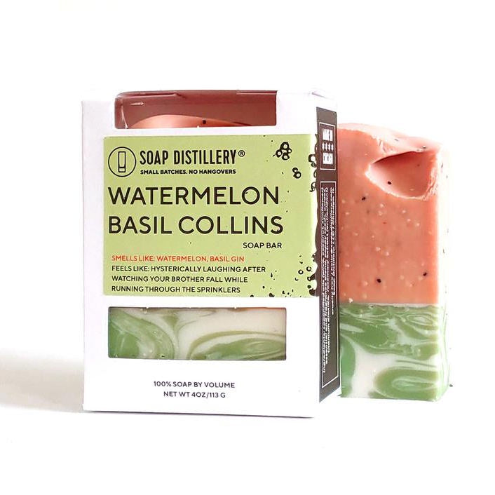 image of side of bar of soap in soft pink with pale green and white swirls, next to the product box in white with logo and information in black on a pale green background