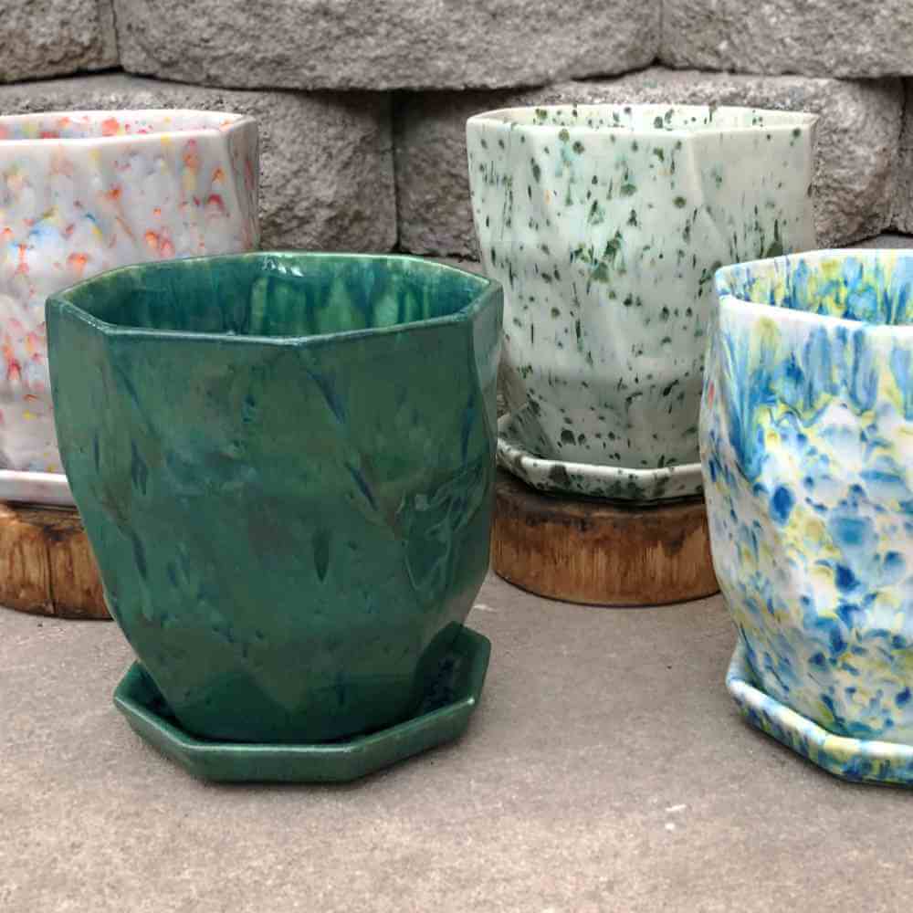 image of 4 ceramic pots, in a tapered octagonal shape, each in a different finish