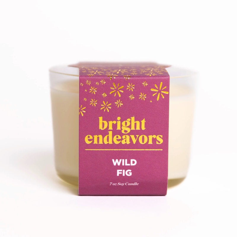 image of off white candle in clear glass jar with deep pink label