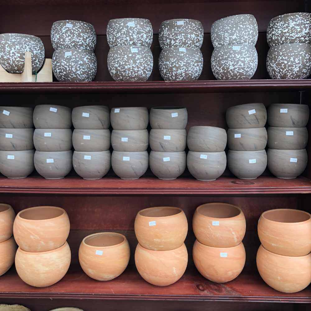 image of a brown shelf unit filled with pottery in blues and white and creamy clay colors