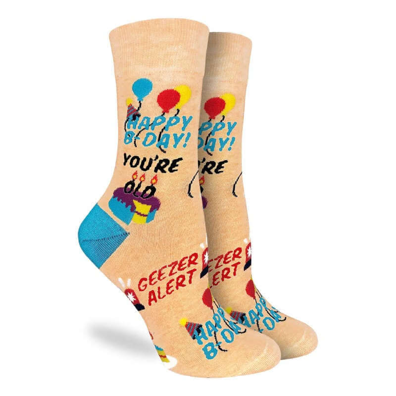 image of a pair of socks in pale gold and happy b-day you're old geezer alert written on them.
