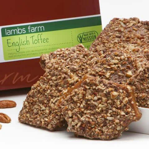 mage of pieces of english toffee topped with crushed pecans.  Box with label in background