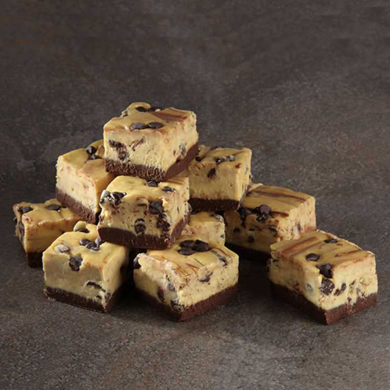 image of several squares of fudge with a chocolate bottom layer and marbled golden layer above mixed with chocolate chips