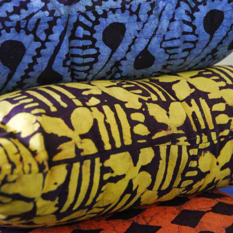 image of three fabrics in rolls...one blue and black one yellow and black and one orange and black