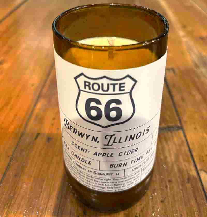 image of a candle in an amber glass jar with a white label sporting black Route 66 symbol and Berwyn Illinois written on it