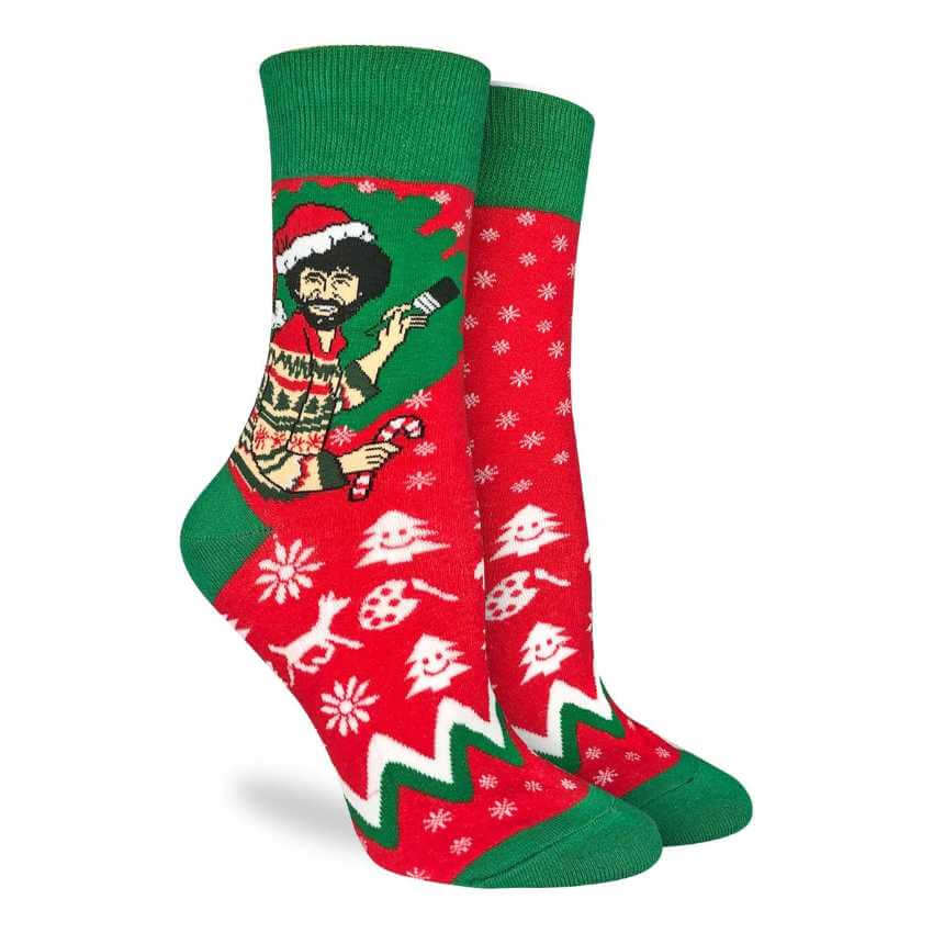 image of red and green socks with a drawing of bob ross holding a candycane and a brush with a santa hat on
