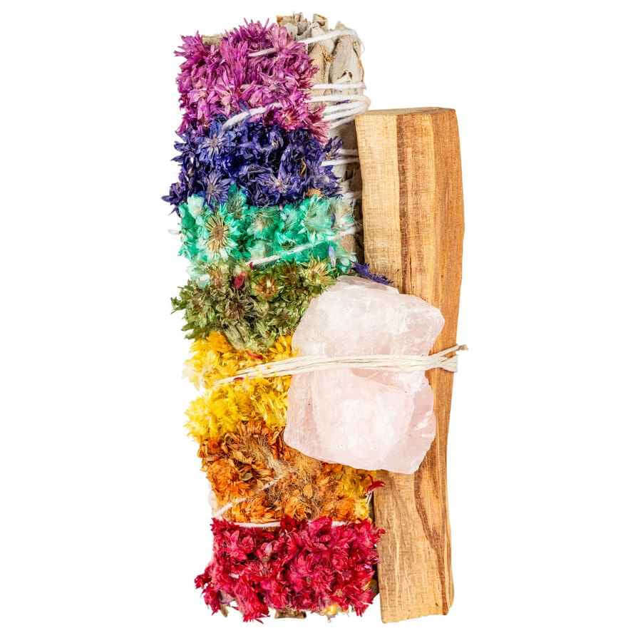 image of piece of palo santo wood tied to a bunch of dried white sage with seven colors of dried flowers representing the seven chakras.  Attached is a piece of rose quartz.