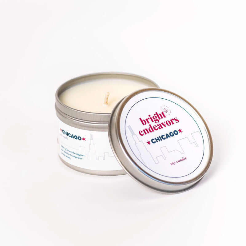 image of white candle in clear glass jar with chicago printed along the top and a drawing of chicago's skyline along the bottom
