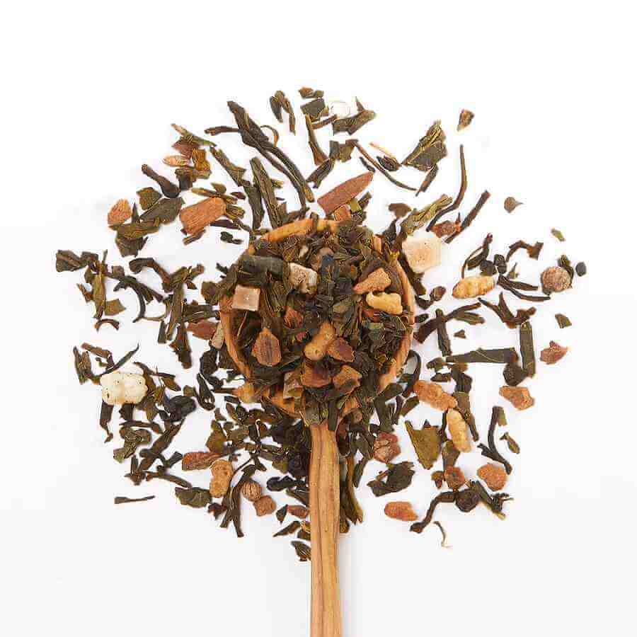 image of round metal container in light green with medium green accents and a carved wooden spoon