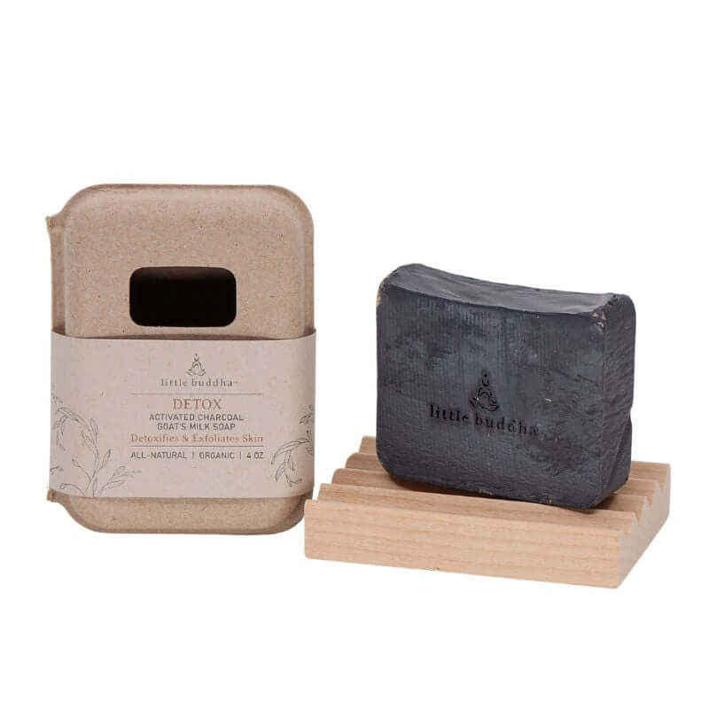 Black soap bar on a wooden stand with 'little buddha' natural paper packaging 
