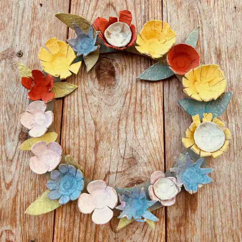 Colorful paper flower wreath on a wooden surface