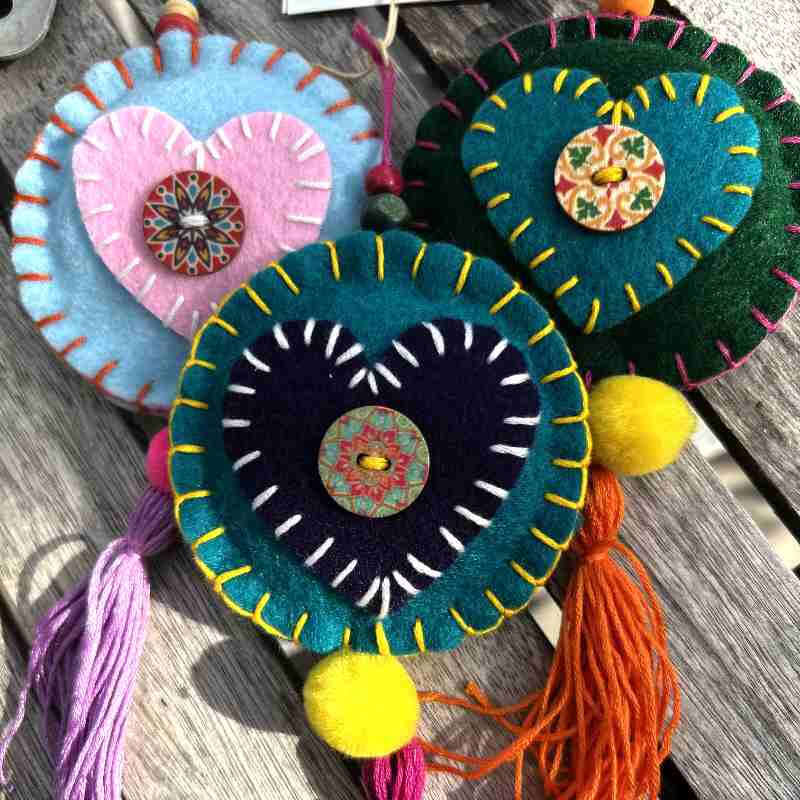 Colorful felt ornaments with tassels on a wooden surface