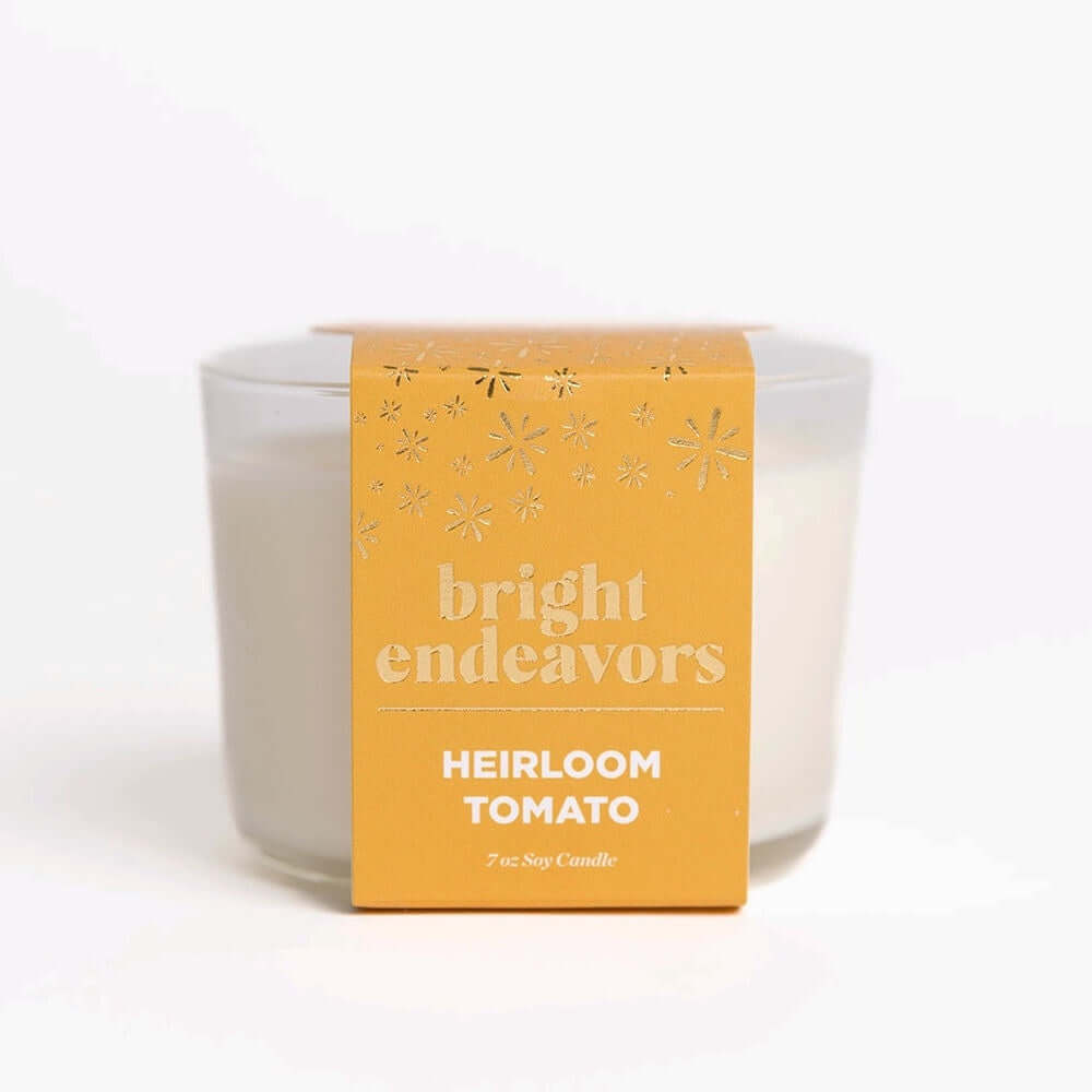 image of white candle in glass jar with bright yellow gold paper wrap
