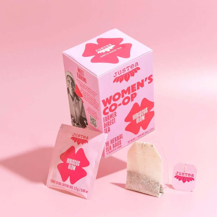 Justea Women's Co-op tea packaging on a pink background
