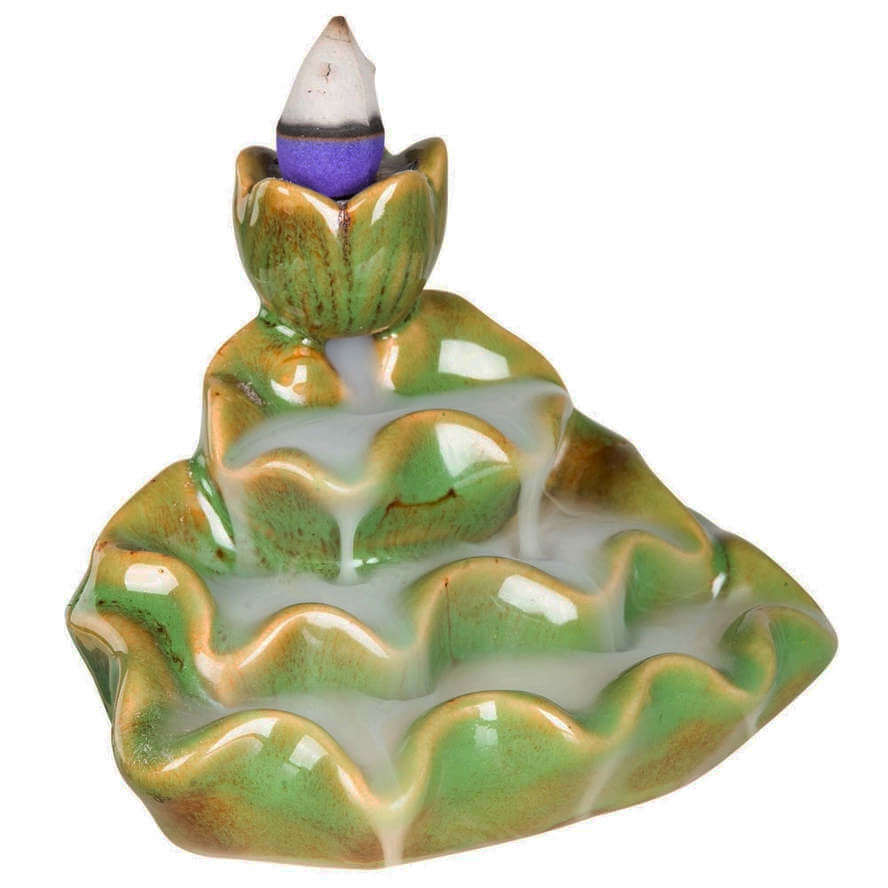 image of green ceramic backflow burner, with a lotus shaped top and rippled cascades down the front, with a lit incense cone and smoke trailing down the front of the burner