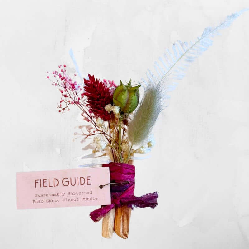 image of small bundle of dried flowers in pink red and green wrapped with bright pink ribbon with a tag attached