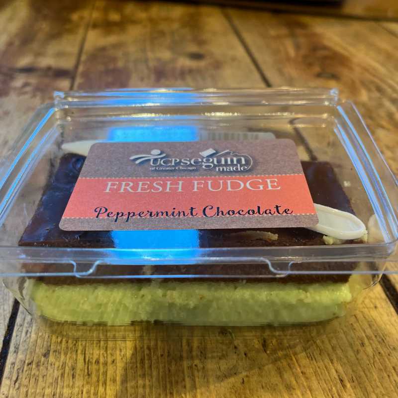 Packaged peppermint chocolate fudge with UCP Seguin label on a wooden surface