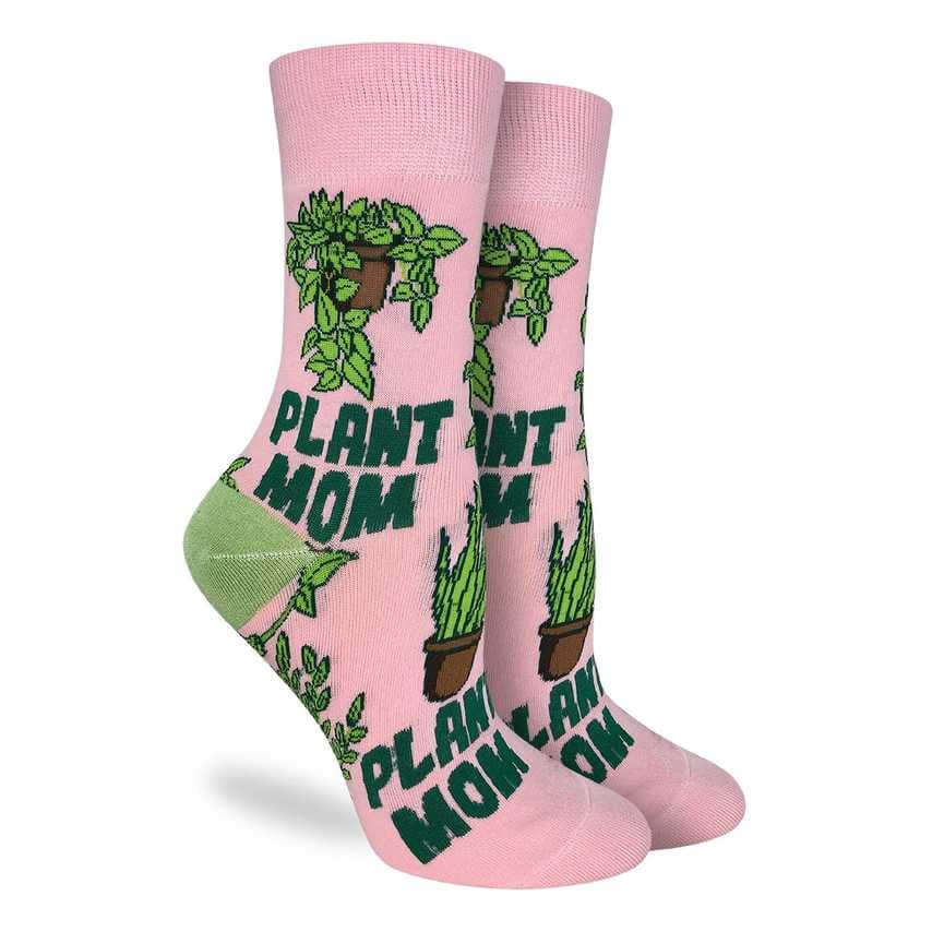 picture of socks in pink with plant mom in dark green and a drawing of a pothos plant and a snake plant