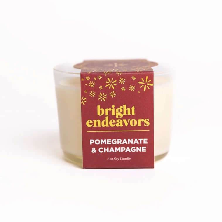 image of off white candle in clear glass jar with dark burgundy paper wrap label