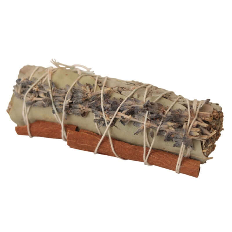 Sage bundle with a cinnamon stick and sprig of dried lavender on a white background