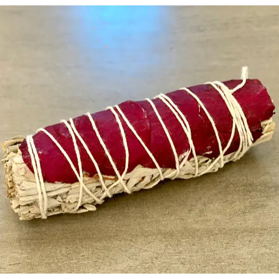 image of three oblong round bundles of sage with red rose petals wrapped in white string