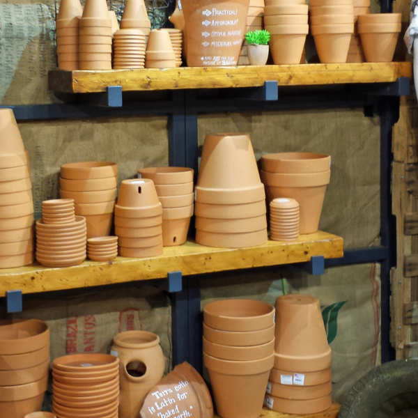 images of wooden shelves with many stacks of clay flower pots on them