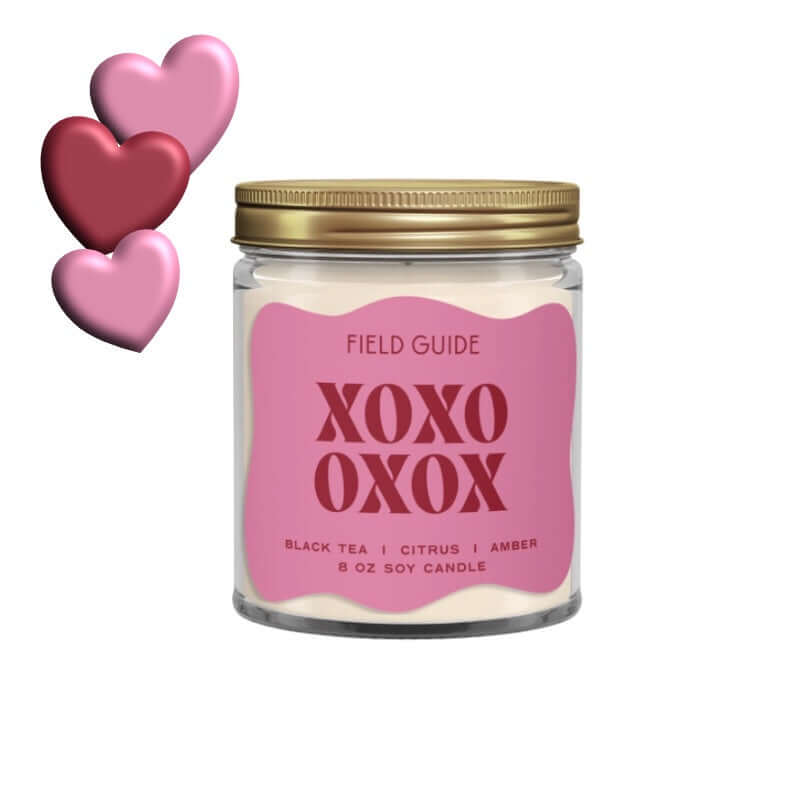 image of white candle in clear jar with pink label and xoxo in red.  3 hearts in pink and red at top left of image
