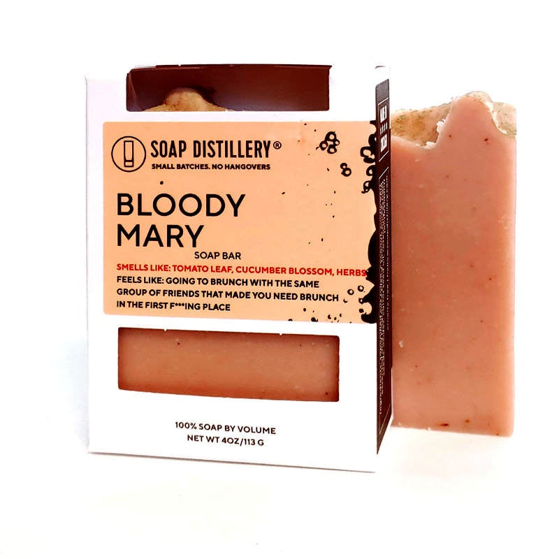 image of bar of soap in peach color, behind a white box with a pale peach label and cutout showing a bar of the peach colored soap