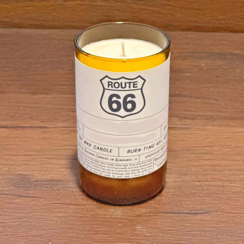 image of a candle in an amber glass jar with a white label sporting black Route 66 symbol