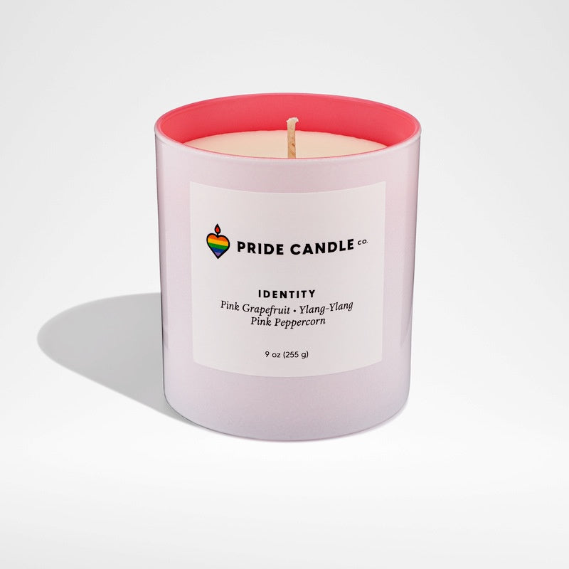 image of simple glass jar with white exterior and sky blue interior, filled with white soy candle.  A white label with Pride Candle logo and description of candle scent.image of simple glass jar with white exterior and pink interior, filled with white soy candle.  A white label with Pride Candle logo and description of candle scent.
