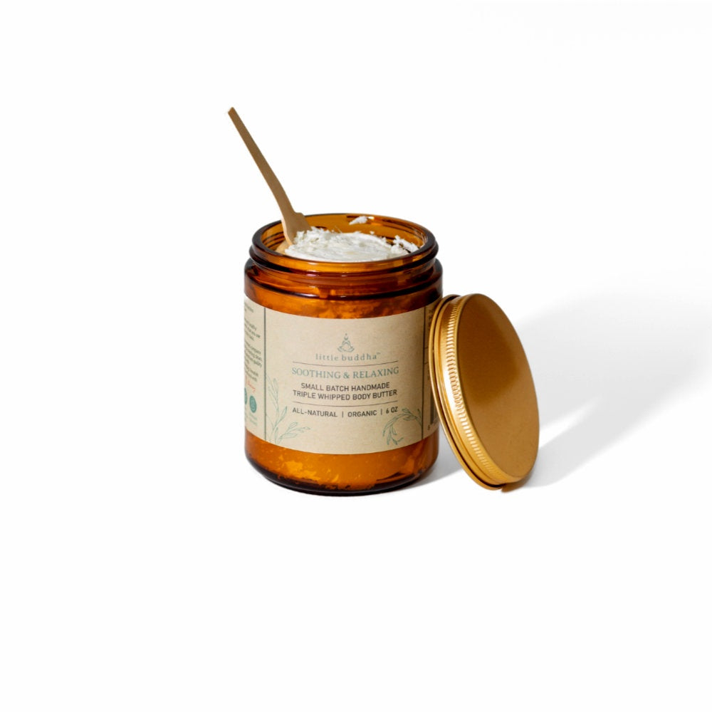 image of amber glass jar with kraft label.  Jar is open with cream colored lotion inside and a small wood paddle in the lotion