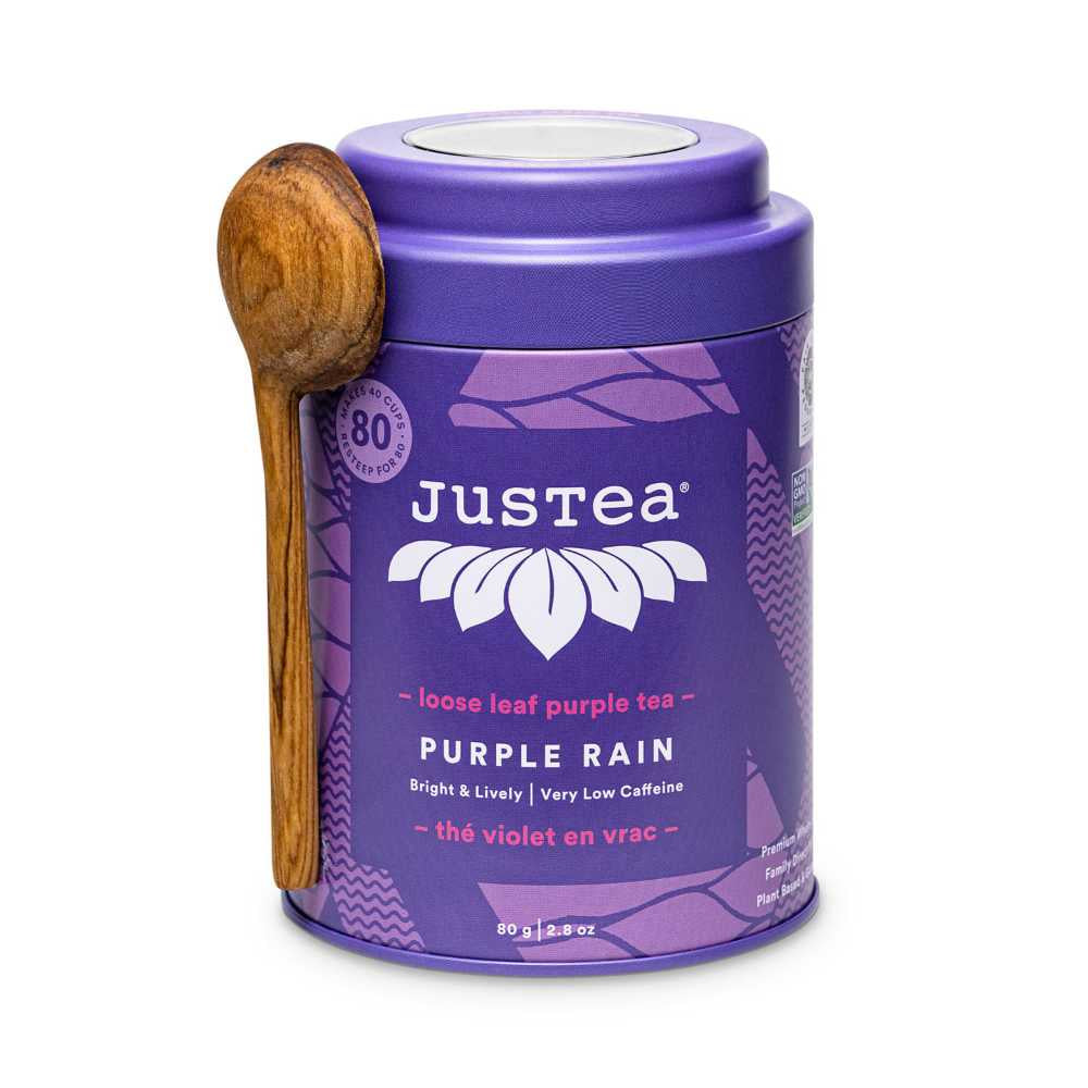image of a round metal can in a purple color with a wooden carved spoon, with brand name and type of tea written in white 