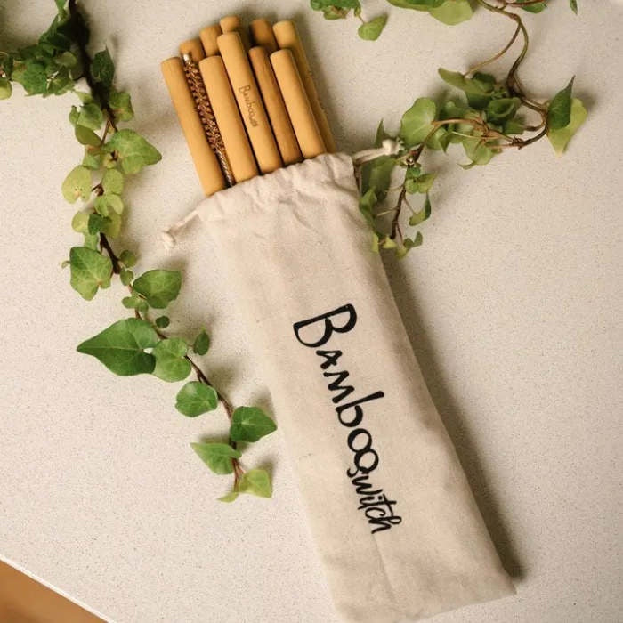 image of bamboo straws sticking out of a linen color cloth bag with ivy vines trailing on each side