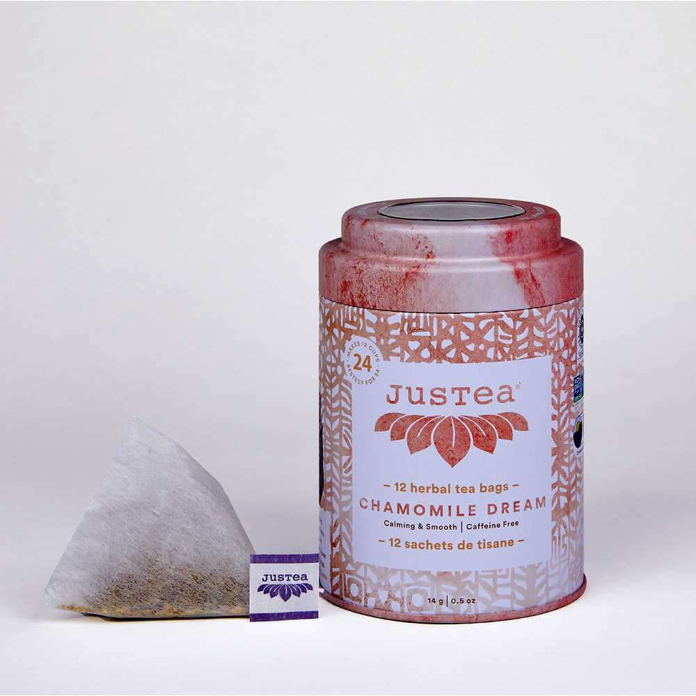 image of round tea tin in white and rose color with a triangular tea bag sitting on the left