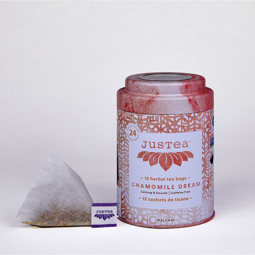 image of round tea tin in white and rose color with a triangular tea bag sitting on the left