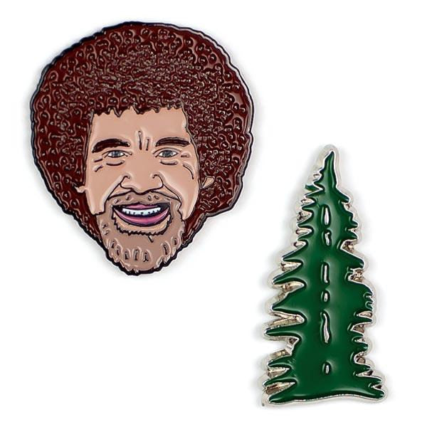 image of two pins.  one of Bob Ross's head and the other of an evergreen tree