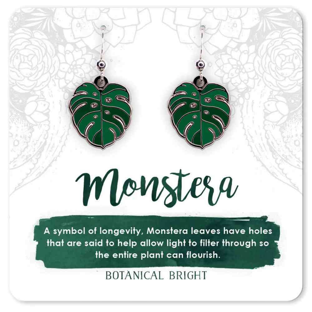 image of pair of earrings in the shape of monstera leaves in dark and medium green.  On a card with description in green and white