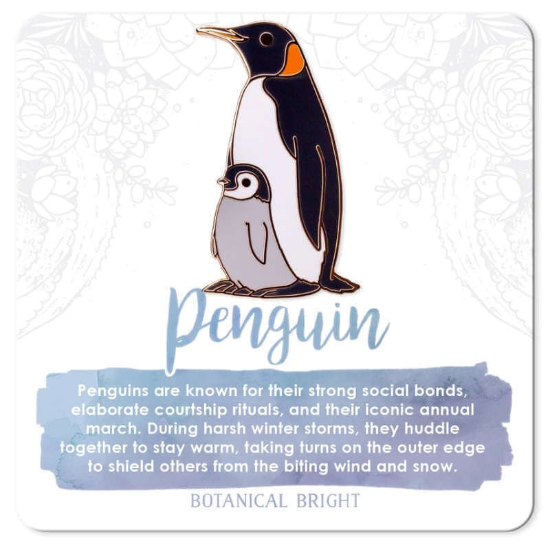 image of enamel pin of an adult penguin with a small penguin chick standing in front.  On a white card with light blue grey writing