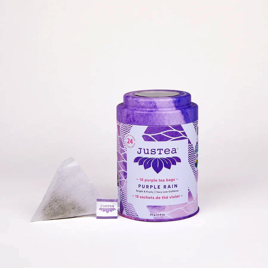 image of round tea tin in white and purple design with a triangular tea bag sitting on the left of the tin