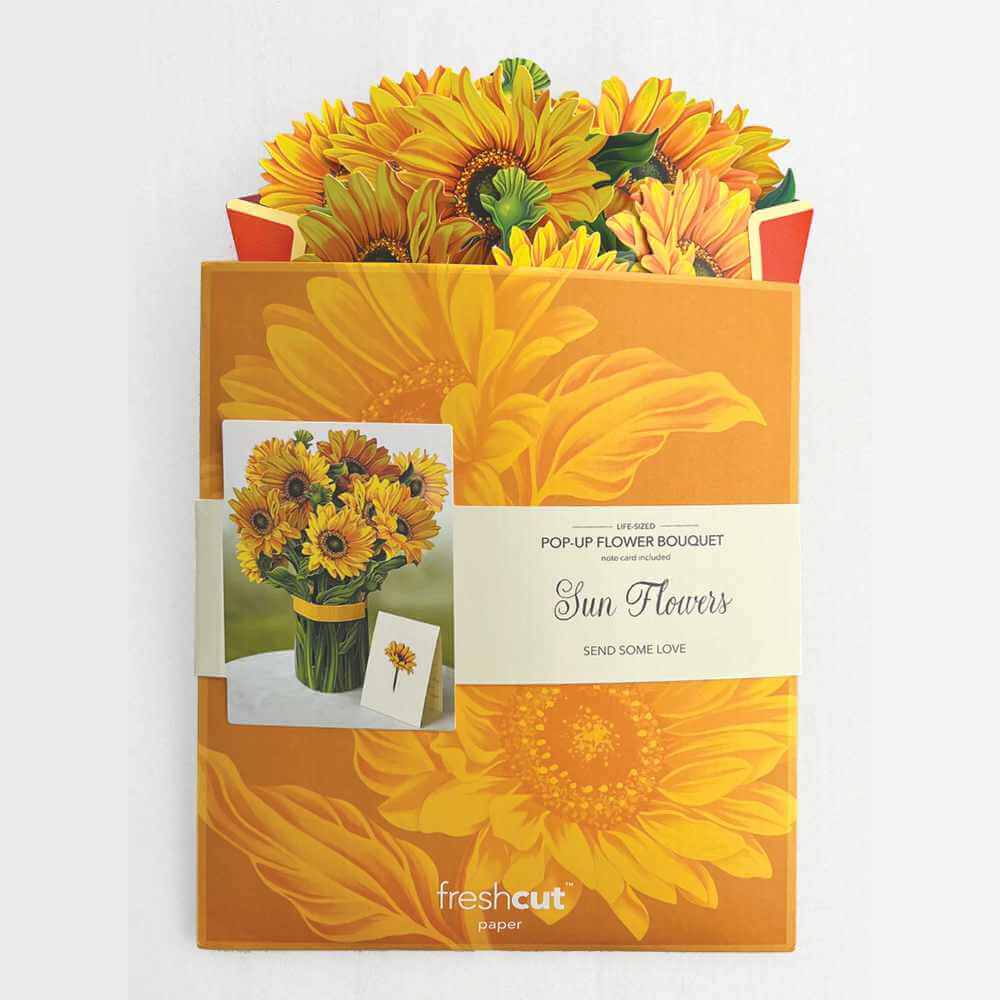 image of the flattened bouquet peeking out of the top of the large envelope it comes in.  Envelope has an large image of sunflowers in bright and dark yellow, with a photo of the fully opened bouquet on it.