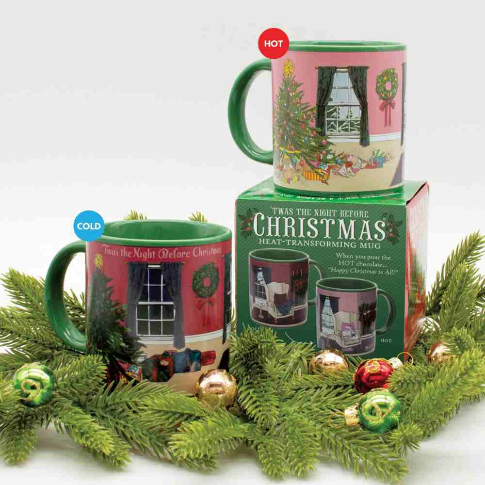 image of gift box for mug, with a mug on top showing what is looks like with a hot beverage, and on the left one showing what is looks like cold.  Surrounded by holiday greens